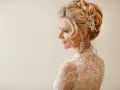 Elegancka fryzura wieczorowa z perłami i kryształowymi kolczykami. Delikatne loki opadają na ramiona.