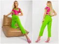 Modelka w stylizacji z intensywnymi odcieniami zieleni. Spodnie i bluzka z wzorem w soczystej zieleni.